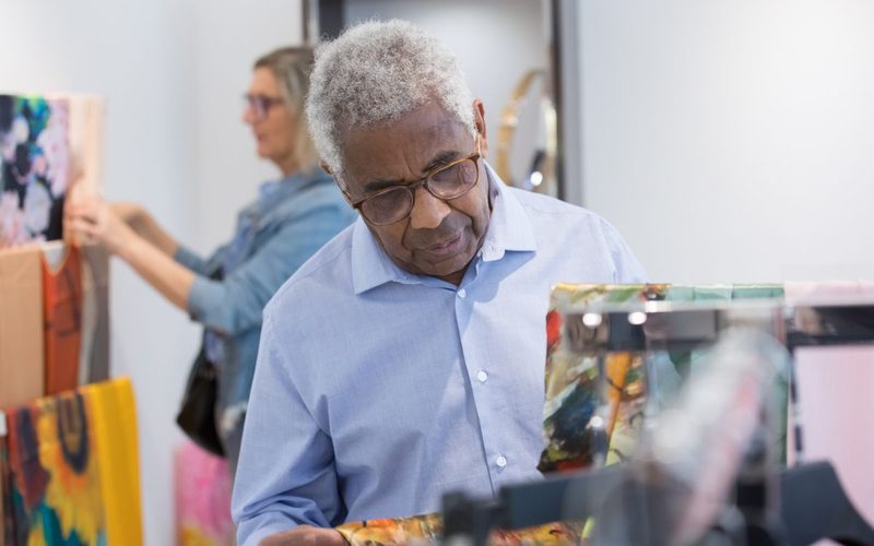 An older shopper showing ID at a store counter — the senior discounts directory